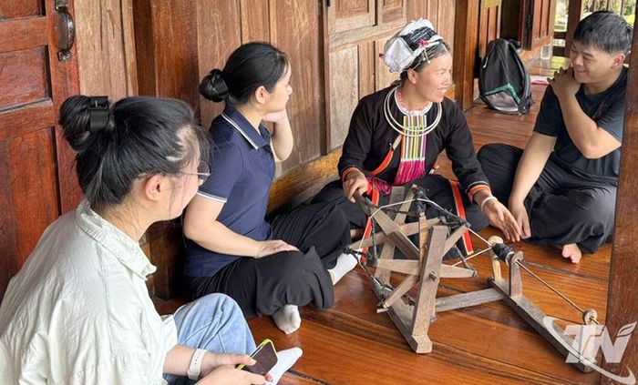 Du khách trẻ trải nghiệm và tìm hiểu nghề dệt, thêu tay truyền thống của người dân thôn Khâu Đấng, xã Bằng Thành.