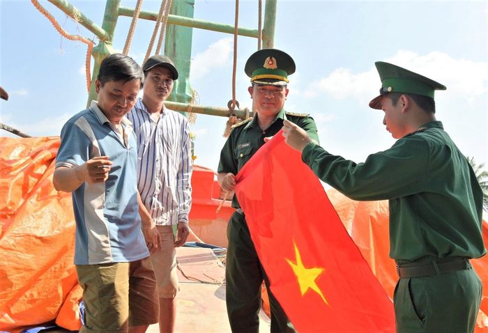 BĐBP An Giang trao tặng cờ nước cho ngư dân trong hoạt động tuyên truyền khai thác hải sản đúng quy định. Ảnh: Tiến Vinh