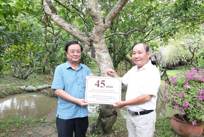 Nguyên Phó Chủ tịch Quốc hội Lê Minh Hoan gắn tuổi cho cây nhãn 45 năm tuổi của gia đình ông Huỳnh Nhất Trí