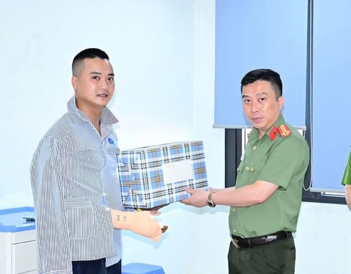 Đại tá Lê Trung Sơn - Phó Giám đốc Công an TP Hải Phòng thăm, động viên Đại úy Nguyễn Đức Thịnh (trái) đang điều trị tại bệnh viện.