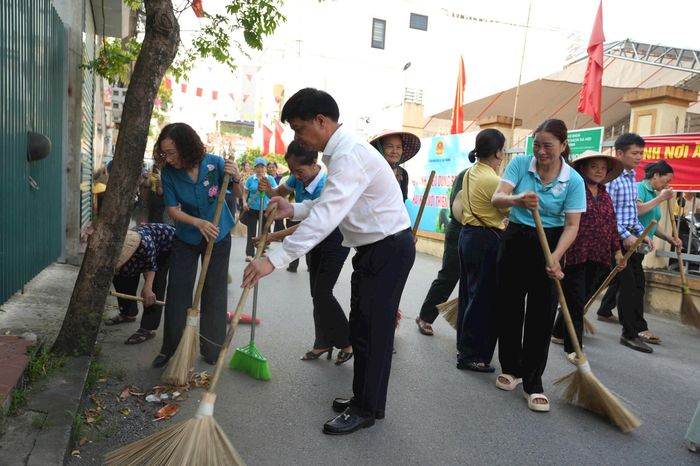 Chủ tịch UBND xã Đan Phượng Nguyễn Viết Đạt, Chủ tịch Ủy ban MTTQ xã Nguyễn Thị Thủy cùng người dân tham gia vệ sinh môi trường. Ảnh: PV