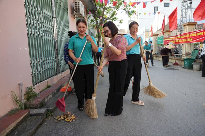 Phó Bí thư Thường trực Đảng ủy xã Đan Phượng Nguyễn Thị Hiền cùng người dân tham gia vệ sinh môi trường. Ảnh: PV
