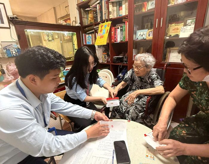 Cán bộ Tổ xung kích Chi nhánh Trung tâm Phục vụ hành chính công số 3 thành phố Hà Nội trực tiếp đến từng hộ gia đình, hỗ trợ người cao tuổi hoàn thiện thủ tục hành chính. Ảnh: PV