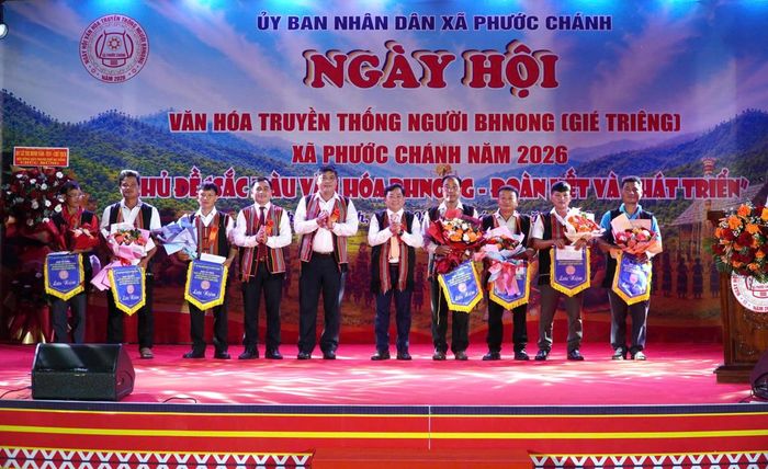 Ban tổ chức tặng cờ lưu niệm cho các đơn vị tham gia Ngày hội văn hóa truyền thống của người Bhnong. Ảnh: TT.