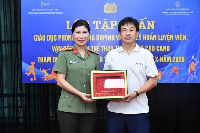 Đại tá Phạm Hồng Thắm - Giám đốc Trung tâm Huấn luyện và Thi đấu thể thao CAND trao tặng logo của Hiệp hội Thể thao CAND cho lãnh đạo Trung tâm Phòng, chống doping Việt Nam
