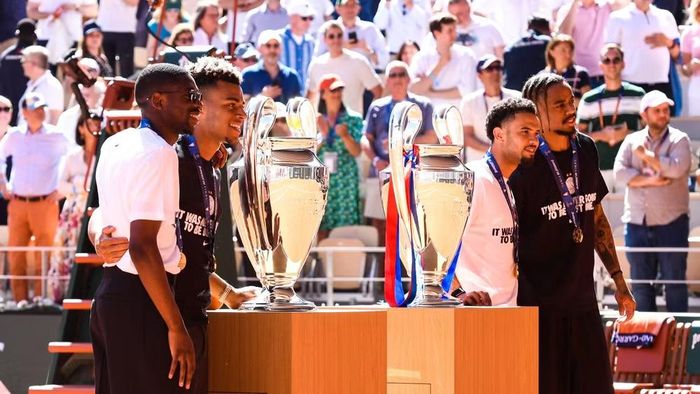 Bốn cầu thủ PSG gồm Ousmane Dembélé, Désiré Doúe, Warren Zaïre-Emery và Bradley Barcola chụp ảnh cùng 2 chiếc cúp vô địch Champions League của câu lạc bộ trên sân Roland Garros. (Nguồn: Liên đoàn Bóng đá Pháp)