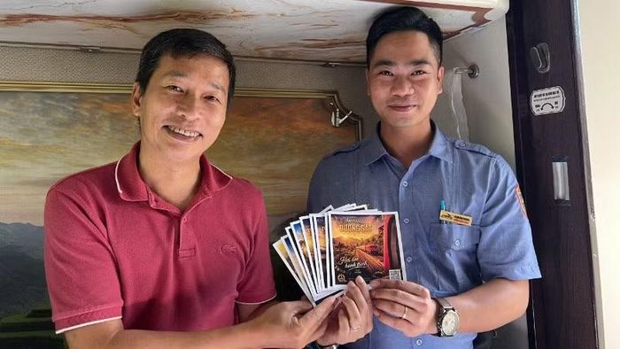 Kỹ sư, nhiếp ảnh gia Trần Vũ Thành (bên trái) trao bưu thiếp có mã QR các bài hát về ngành đường sắt cho nhân sự trên tàu.