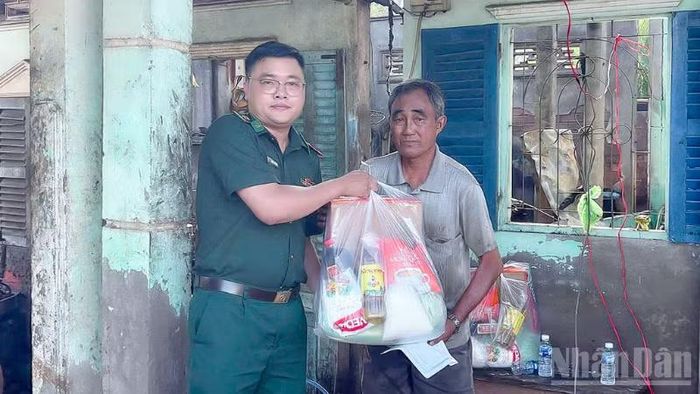 Thiếu tá Huỳnh Lý Tưởng, Chính trị viên đồn Biên phòng Trung Bình, đến thăm hỏi động viên và tặng quà cho 2 hộ gia đình bị hỏa hoạn.