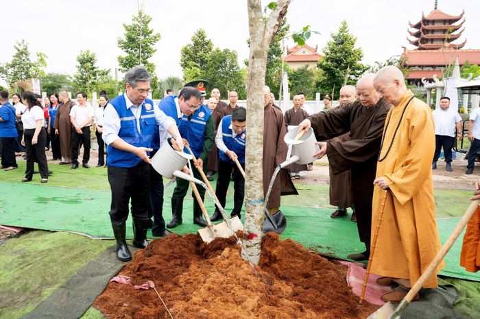  Đồng chí Nguyễn Phước Lộc cùng các đại biểu tưới nước cho cây xanh sau khi trồng. Ảnh: QUỐC THANH 