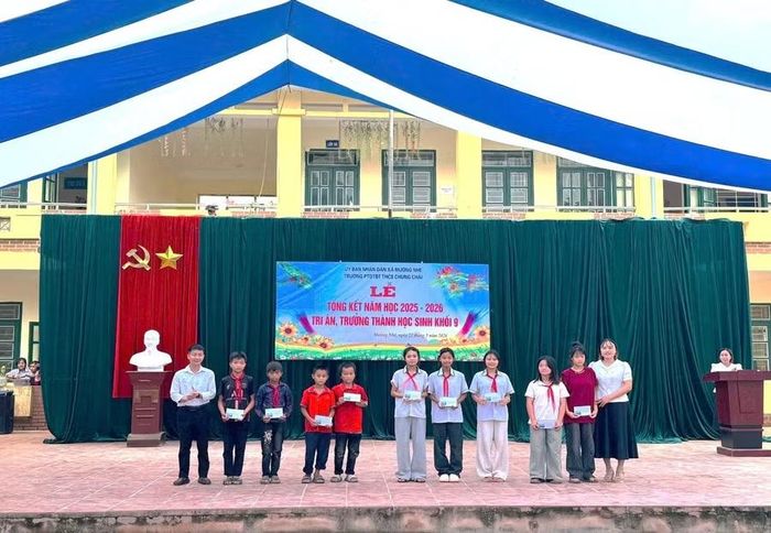 Thầy giáo Nguyễn Văn Quynh - Hiệu trưởng nhà trường (ngoài cùng bên trái) trao quà, động viên học sinh nỗ lực vượt khó.