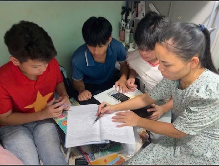 Cô Trần Thị Ngát hướng dẫn các em học sinh ôn thi tại phòng ký túc xá trong đêm.