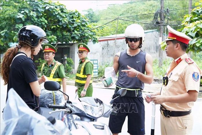 Lực lượng Cảnh sát giao thông Công an tỉnh Tuyên Quang kiểm tra điều kiện của các phương tiện và người điều khiển phương tiện đưa đón khách du lịch. Ảnh: Hồng Hạnh/TTXVN phát