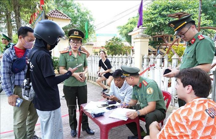 Cán bộ Phòng Quản lý Xuất nhập cảnh Công an tỉnh Tuyên Quang kiểm tra giấy tờ xuất nhập cảnh, hộ chiếu, thị thực của người nước ngoài. Ảnh: Hồng Hạnh/TTXVN phát