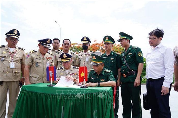 Bộ đội Biên phòng tỉnh An Giang và lực lượng bảo vệ biên giới Campuchia ký biên bản bàn giao. Ảnh: TTXVN phát