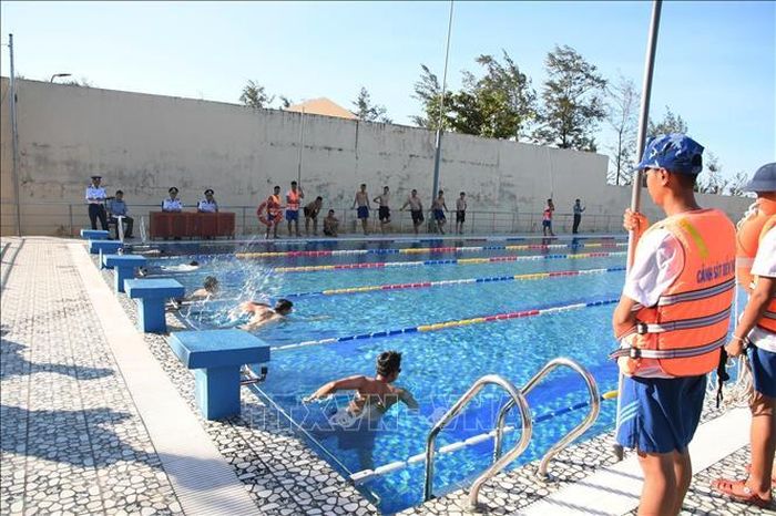 Các cán bộ, chiến sĩ, đoàn viên tham gia phần thi bơi tại bể bơi Bộ Tư lệnh Vùng Cảnh sát biển 2. Ảnh: TTXVN phát