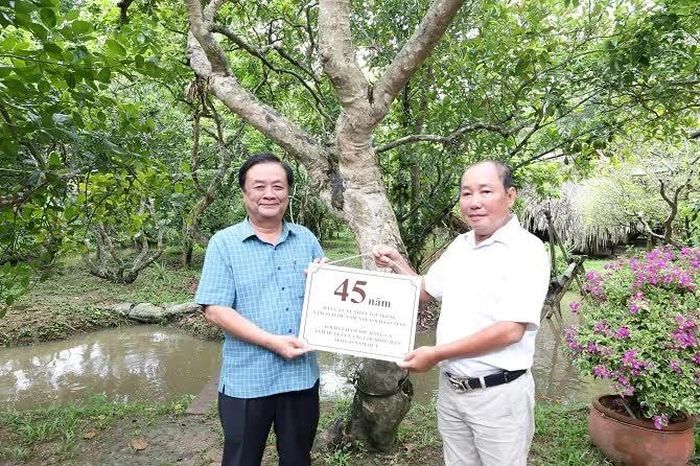 Ông Huỳnh Nhất Trí nhận bảng tuổi cho cây nhãn từ nguyên Phó Chủ tịch Quốc hội Lê Minh Hoan.