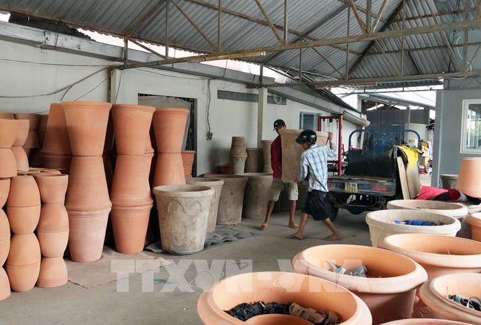 Vận chuyển sản phẩm gốm đỏ về kho sau khi hoàn thiện. Ảnh: Phạm Minh Tuấn-TTXVN 