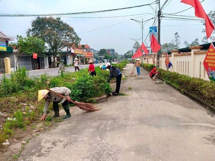 Hội viên phụ nữ xã Quảng Ninh tham gia dọn vệ sinh ở khu dân cư.
