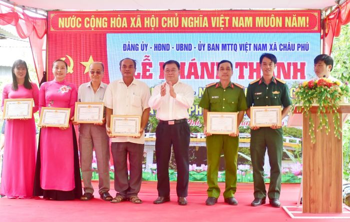 Ủy viên Ban Thường vụ Tỉnh ủy, Phó Chủ tịch Thường trực Ủy ban MTTQ Việt Nam tỉnh Lê Thanh Việt (thứ năm, từ trái qua) khen thưởng các tập thể, cá nhân đóng góp tích cực vào quá trình thi công cầu.