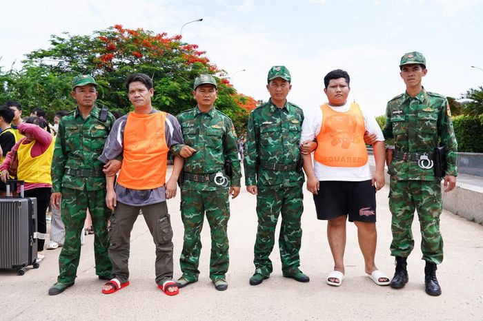 Hai đối tượng Lâm Quang Nhật (thứ 2, từ trái sang) và Nguyễn Tán Luân (thứ 2, từ phải sang) có lệnh truy nã bị lực lượng Biên phòng tỉnh An Giang bắt giữ tại cửa khẩu.