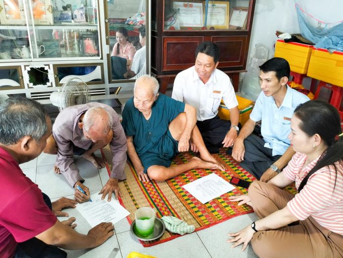 Cán bộ xã Tân Hội xuống tận nhà hỗ trợ chứng thực chữ ký trong giấy ủy quyền nhận tiền bảo trợ xã hội cho người già khó khăn đi lại.