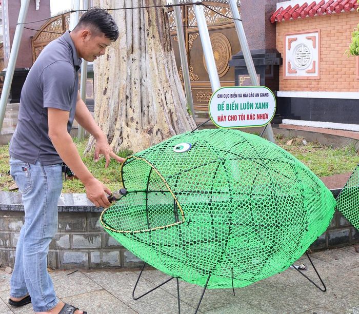 Người dân bỏ rác thải nhựa vào lồng chứa đặt trước cổng Đền tưởng niệm Anh hùng liệt sĩ và người có công tỉnh.