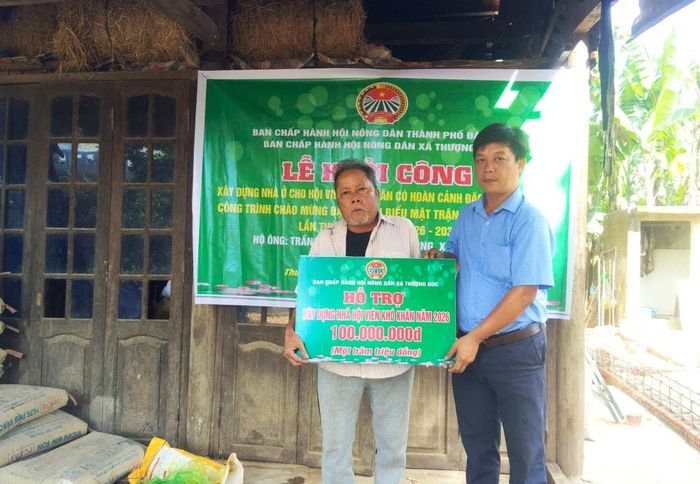 Đại diện Hội Nông dân xã Thượng Đức trao 100 triệu đồng hỗ trợ ông Trần Lăng xây dựng nhà. Ảnh: T.T