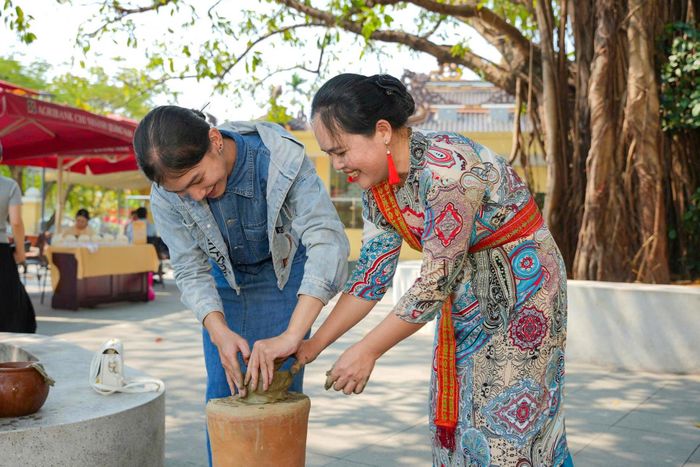 Du khách trải nghiệm hoạt động nặn gốm của người Chăm trong chương trình “Chăm Hội - Vũ Khúc Giao Duyên”, do sinh viên Trường Đại học FPT Đà Nẵng thực hiện. Ảnh: ĐVCC