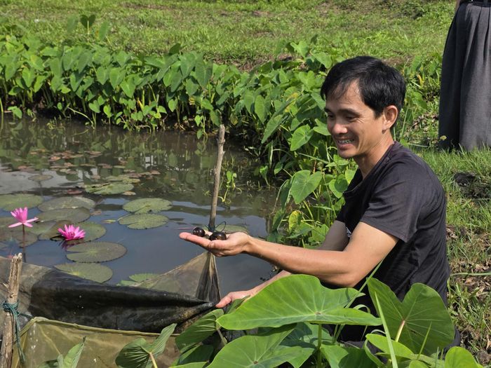 Anh Huỳnh Ngọc Nam đầu tư trang trại nuôi cá nước ngọt và ốc bươu trên diện tích 4,5ha từ vốn vay hỗ trợ tạo việc làm. Ảnh: H.A