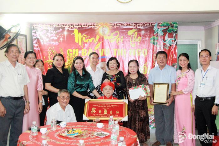 Đoàn công tác tặng thiếp, quà của Chủ tịch nước và khánh chúc thọ của Thành ủy - HĐND - UBND - Ủy ban MTTQ Việt Nam thành phố cho cụ Vũ Thị Ngọ, ở khu phố Đồng Tâm, phường Trấn Biên. Ảnh: Nga Sơn