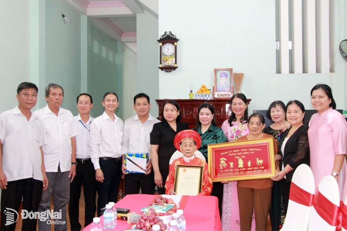 Đoàn công tác tặng thiếp, quà của Chủ tịch nước và khánh chúc thọ của Thành ủy - HĐND - UBND - Ủy ban MTTQ Việt Nam thành phố cho cụ Nguyễn Thị Chấp, ở khu phố Tân Bửu, phường Trấn Biên. Ảnh: Nga Sơn