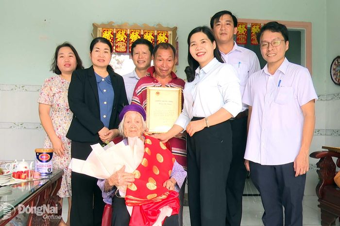 Lãnh đạo Đảng ủy, HĐND, UBND, Ủy ban MTTQ Việt Nam xã Bàu Hàm tặng quà của Chủ tịch nước cho các cụ tròn 100 tuổi. Ảnh: Trần Nguyên