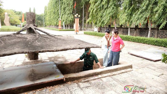 Cựu chiến binh Lê Thanh Hải giới thiệu hệ thống địa đạo tại Di tích lịch sử cấp quốc gia Địa đạo Nhơn Trạch cho 2 MC và khán giả của "Khám phá Đồng Nai". Ảnh: Tiến Dũng