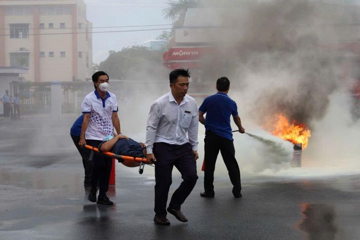 Lực lượng tham gia diễn tập triển khai phương án cứu người bị nạn ra khỏi khu vực cháy bằng cáng chuyên dụng.