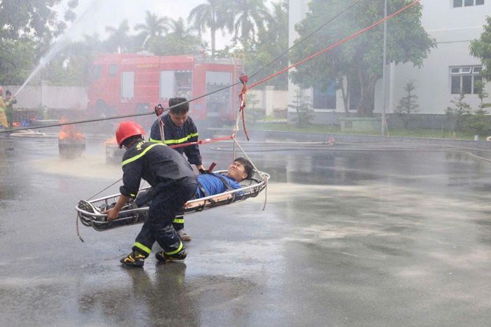 Lực lượng cứu nạn cứu hộ tiếp nhận và đưa người bị nạn xuống đất an toàn trong tình huống giả định xảy ra cháy tại tòa nhà điều hành.
