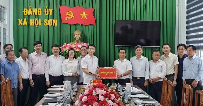  Phó Bí thư Tỉnh ủy Nguyễn Ngọc Lương (thứ 7 từ phải sang) tặng quà cho Đảng ủy xã Hội Sơn. Ảnh: Đức Hải 