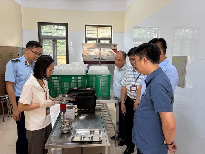 Cán bộ Chi cục ATTP tỉnh thực hiện xét nghiệm khay đựng cơm, thức ăn phản ứng hồ tinh bột với dung dịch (KI+I) tại Trường Tiểu học Nam Phong (phường Vị Khê)