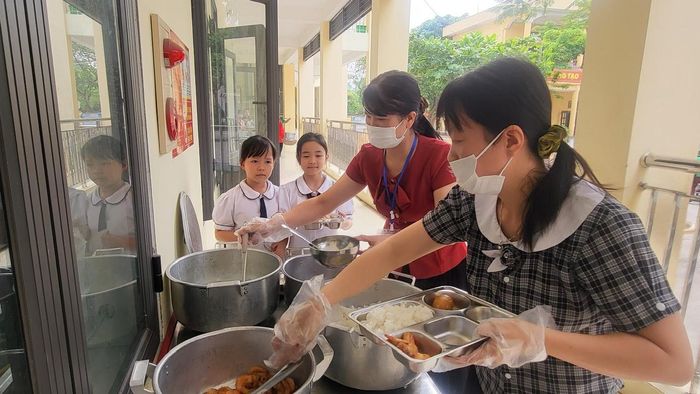 Nhân viên bếp ăn tại Trường Tiểu học Đông Thành (phường Hoa Lư) thực hiện chia khẩu phần ăn cho học sinh.