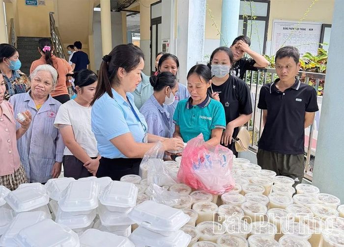 Cán bộ Trung tâm Y tế khu vực Đà Bắc phát cơm miễn phí cho bệnh nhân có hoàn cảnh khó khăn.