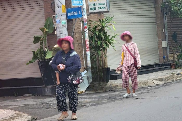 Một người bán vé số cõng theo con nhỏ trên đường Trần Hưng Đạo, phường Tăng Nhơn Phú, sáng 4/6. Ảnh: Quang Phương