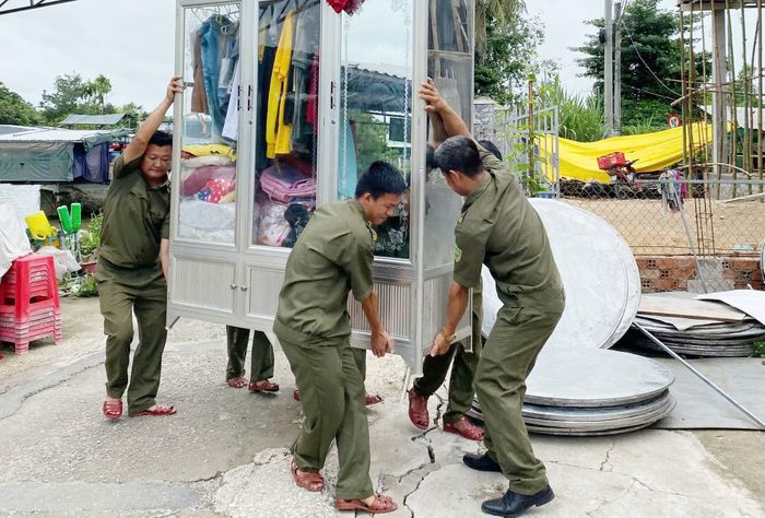 Công an phường Ô Môn và lực lượng tham gia đảm bảo ANTT cơ sở hỗ trợ di dời tài sản của hộ gia đình ông Tấn đến nơi an toàn.
