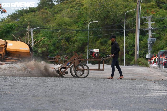 Trên công trường, bất chấp điều kiện thời tiết thay đổi, nhiều mũi thi công vẫn duy trì hoạt động. Xe lu, xe ben, máy trải nhựa cùng hàng trăm công nhân đang tập trung hoàn thiện hệ thống thoát nước, bó vỉa, dải phân cách và các hạng mục phụ trợ khác.