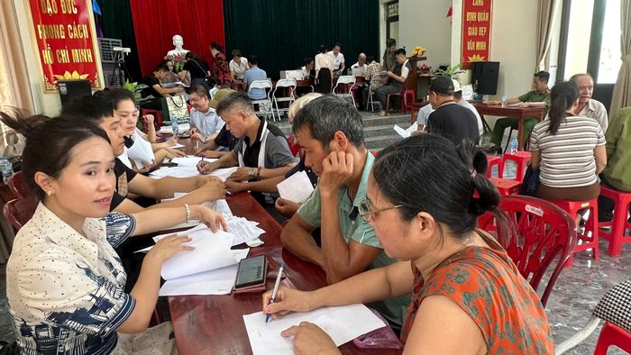 Người dân thôn Định Quán hoàn thiện thủ tục trước khi nhận tiền chi trả bồi thường GPMB dự án án. Ảnh: PV