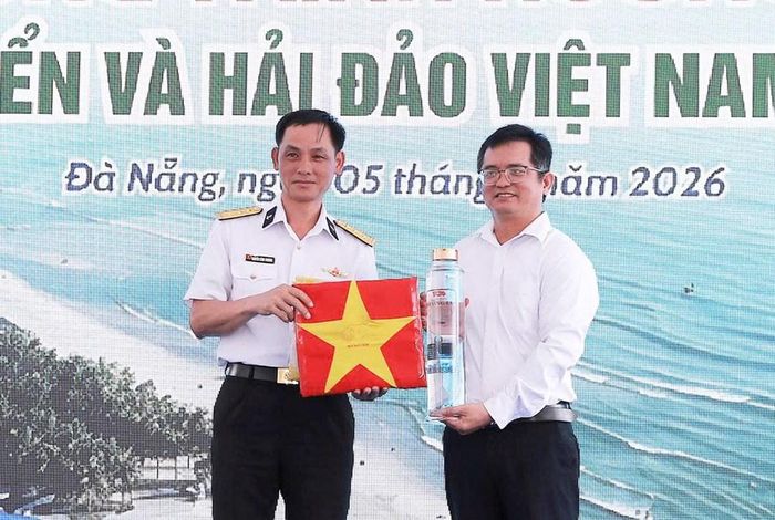 Đại diện Nhà trưng bày Hoàng Sa đón nhận món quà đặc biệt từ Lữ đoàn 161 gồm nước biển được mang về từ vùng biển Hoàng Sa và lá cờ Tổ quốc có chữ ký của cán bộ, chiến sĩ đơn vị