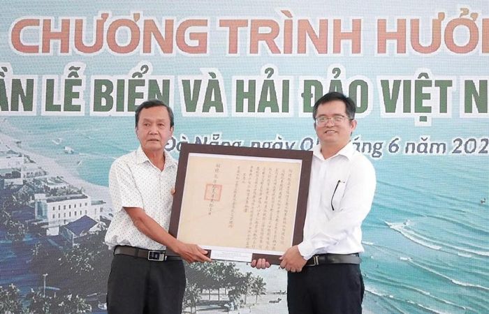 Ông Mai Văn Khôi, đại diện tộc Mai Văn (bên trái) trao tặng tư liệu cho Nhà Trưng bày Hoàng Sa