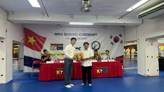 Chủ nhiệm Trung tâm Taekwondo Kids Việt Nam Trịnh Minh Thái trao quà lưu niệm tặng lãnh đạo Korea Black Belt Center