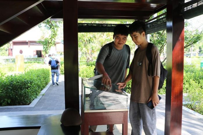 Du khách tìm hiểu hiện vật tại Nhà sàn Bác Hồ. Ảnh: Hồng Thái - TTXVN