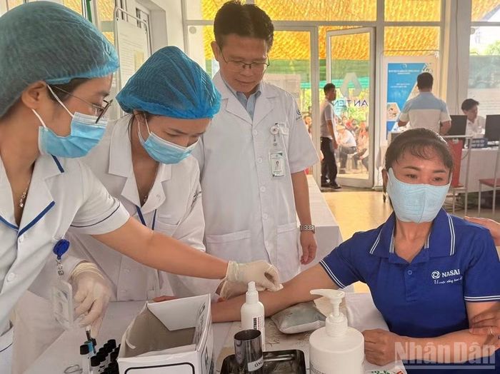 Lấy mẫu máu xét nghiệm cho công nhân.