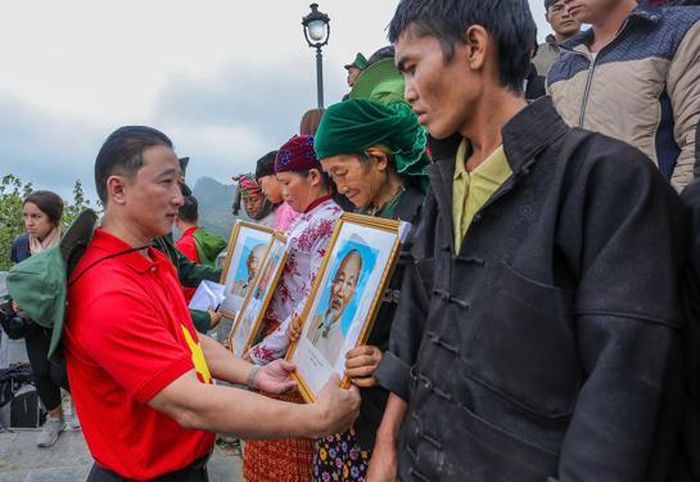 Phó Tổng Biên tập Báo Người Lao Động Bùi Thanh Liêm trao ảnh Bác Hồ tặng người dân tại cột cờ Lũng Cú .Ảnh: NGÔ NHUNG