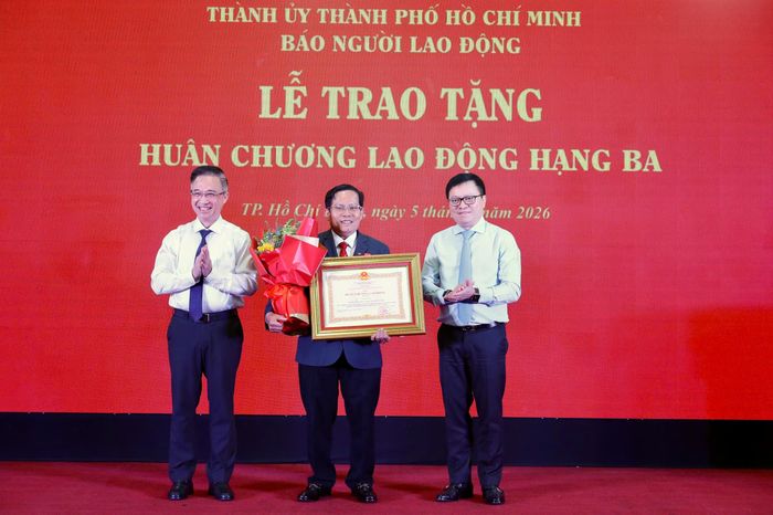 Ông Lê Quốc Minh - Ủy viên Trung ương Đảng, Phó Trưởng Ban Tuyên giáo và Dân vận Trung ương, Chủ tịch Hội Nhà báo Việt Nam, Tổng Biên tập Báo Nhân Dân (bìa phải) và Phó Bí thư Thành ủy TPHCM Đặng Minh Thông, chúc mừng Nhà báo Tô Đình Tuân nhận Huân chương Lao động hạng Ba.